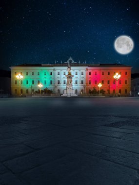 Sassari, Piazza d 'Italia Meydanı, İtalyan bayrağının renkleriyle aydınlatılmış tarihi bina, gerçeküstü parlak bir ay ile rüya gibi bir gece.