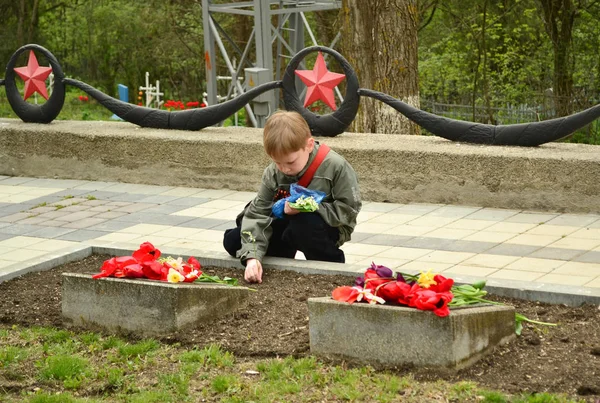 Pyatigorsk, Rusland - 09 mei 2011: Boy leggen bloemen naar het monument aan de gevallen soldaten van de Tweede Wereldoorlog — Stockfoto