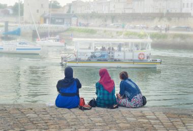 La Rochelle, Fransa - 12 Ağustos 2015: hijab seyir giyen Müslüman kadın okyanus ve yatlar, La Rochelle, Fransa.