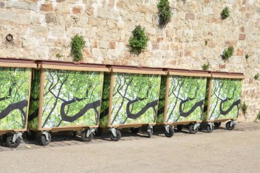 üst üste tarihsel duvarının yakınında duran çöp çöp kovaları