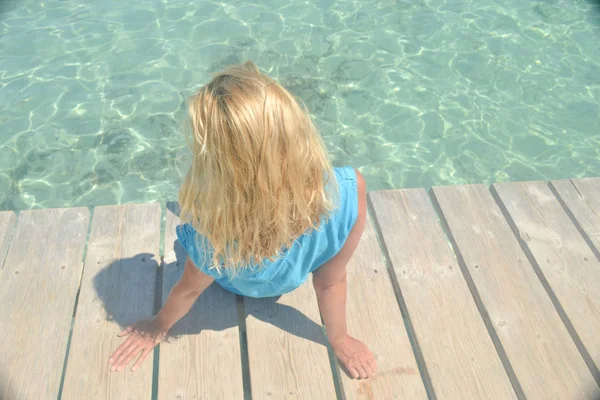 Loira com cabelos ondulados na costa do mar azul-turquesa — Fotografia de Stock