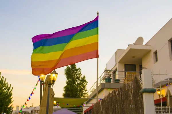 Bandera lgbt contra el telón de fondo del sol en un bar al aire libre —  Fotos de Stock