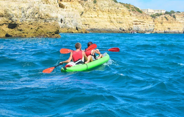 Casal kanoeing no oceano com montanhas — Fotografia de Stock