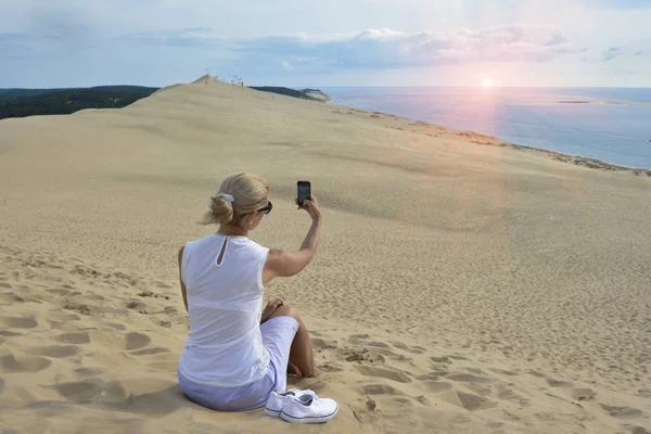 Блондинка делает селфи для инстаграма в дюне Пила, самой большой песчаной дюне в Европе — стоковое фото