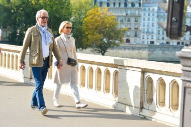 Paris, Fransa - 16 Ekim 2016: İyi giyimli bir yaşlı çift bir Paris, Fransa yürüyor.