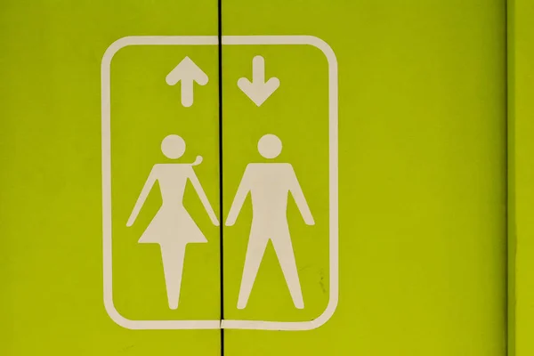 The symbols with an arrow pointing down and up on a green elevator