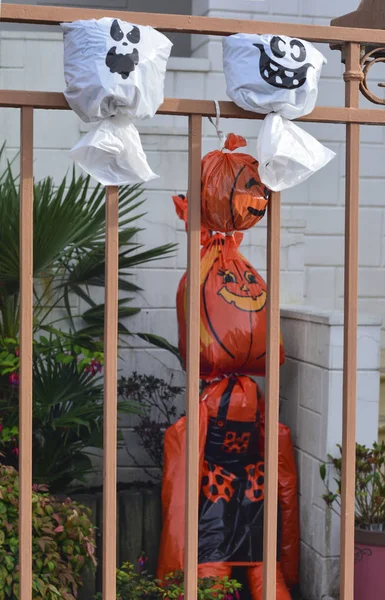 Artificial pumpkin heads from a plastic bag on the fence. Halloween — Stock Photo, Image