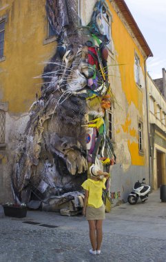 Porto, Portekiz - 12 Ağustos 2017: Graffiti ve eski bir sarı ev duvarında bir tavşan rakam şeklinde otomobillerin armatürler