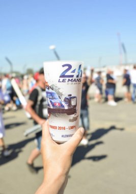 Le Mans, Fransa - 18 Haziran 2017: Bir el bir plastik bardak bira ile bir fotoğraf ile kazanan araba yarış sırasında 24 saat tutar