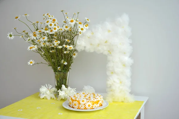 Un ramo de manzanillas y un pastel de cumpleaños para niñas durante 1 año — Foto de Stock