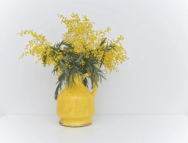 Ramo de mimosa en jarrón amarillo agrietado vintage — Foto de Stock