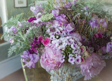 Bir buket pembe şakayık orkideler yeşil yaprak ve dekoratif bitkiler