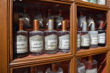 Eski bir eczanede cam şişelerdeki ilaçlarla rafta.