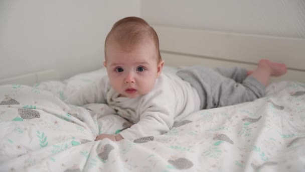 Un bebé de cuatro meses yace boca abajo — Vídeo de stock