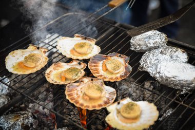 Izgara deniz tarağı, otlar ve sıcak patatesler.