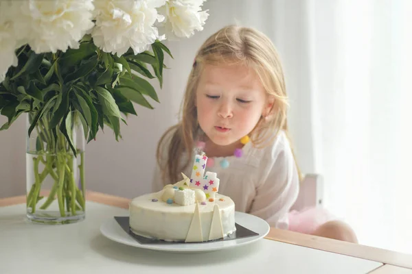 A girl of 4 years old making wish blowing candles on a cake — Stock Photo, Image