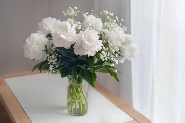 Bílé pivoňky květiny s gypsophila ve váze na bílém pozadí — Stock fotografie