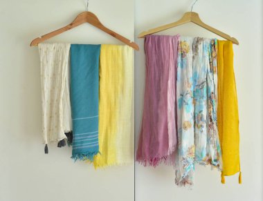Multi-colored scarves hang on a hanger in a wardrobe