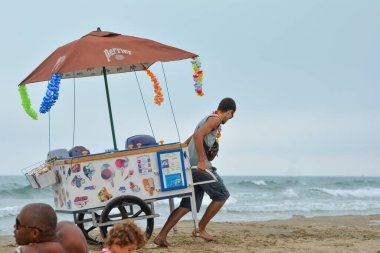 CAP D 'AGDE, FRANCE - 30 HAZİRAN 2016: Bir adam plajda dondurmalı bir araba çekiyor. Eğlence arabası.