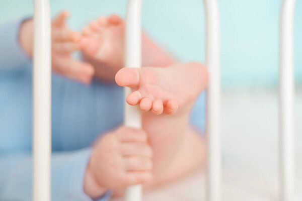 Feet and heels of a four months old baby lying on the bed at home