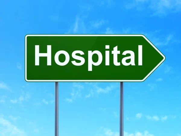 ヘルスケアの概念: 道路標識の背景に病院 — ストック写真