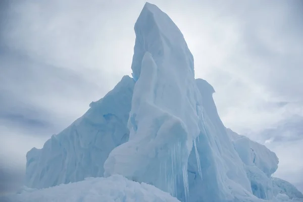 Spitze des Eisbergs vor wolkenverhangenem Himmel in der Antarktis — Stockfoto
