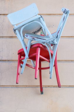 Bir duvara kırmızı ve mavi ahşap sandalye