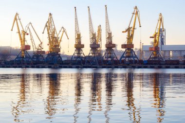 Odessa, Ukrayna - Januadry 02, 2017: Konteyner Vinç kargo Port terminal, kargo Vinçler suya yansıyan. Günbatımı