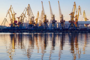 Odessa, Ukrayna - Januadry 02, 2017: Konteyner Vinç kargo Port terminal, kargo Vinçler suya yansıyan. Günbatımı