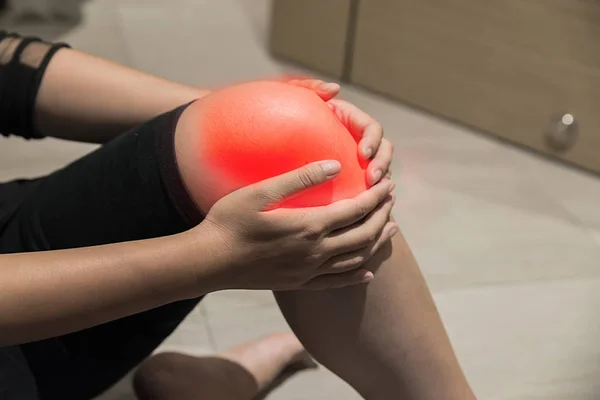 women has inflammation and swelling cause a pain the sore knee, sport physical injuries when working out.