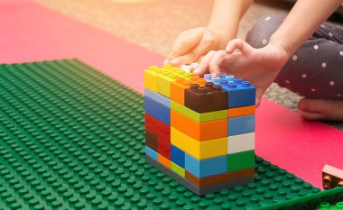 Renkli plastik bloklarla oynama çocuğun el kapatın. Okul öncesi çocuk renkli oyuncak bloklarla oynama. Okul öncesi çocuklar plastik blok ile kule inşa.