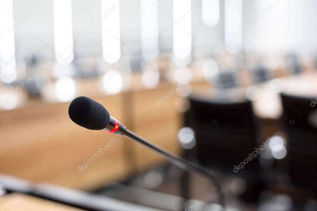 Close up Microphone over the Abstract blurred of conference hall or seminar room background.