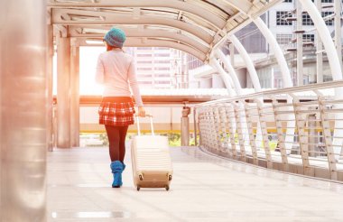 Genç kadın bavulun içinde modern Havaalanı terminal, ile onun Bagaj Taşıma, arkadan görünüş için beklerken çekip turist çekerek. Kopya alanı