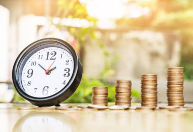 Saat alarm ve adım para yığınları, doğa arka plan, para, kaydetme ve siluet sesi flare yatırım veya aile planlaması kavramı, güneş üzerinde.