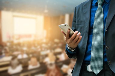 istimal hareket eden telefon ile katılan arka plan konferans salonu veya seminer odası bulanık, işadamı.