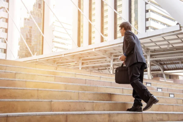 Empresario caminando por las escaleras con el fondo de la ciudad, Empresarios van al concepto de éxito . — Foto de Stock