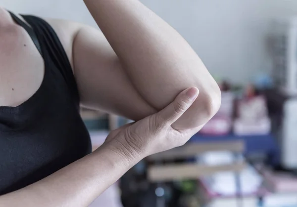 Dolor de codo. Las mujeres toman la mano en su codo doloroso, lesiones físicas deportivas cuando hacen ejercicio . —  Fotos de Stock