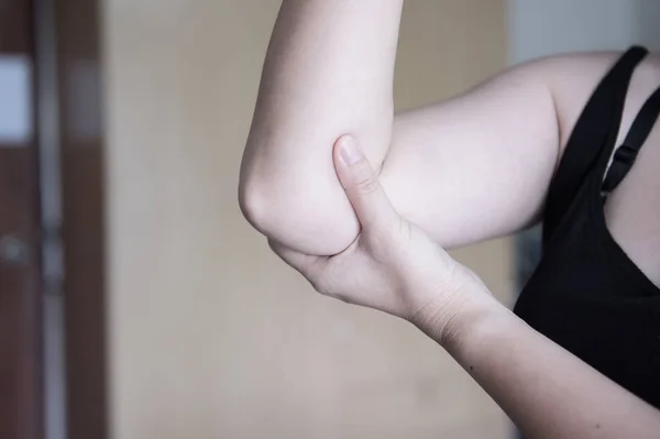 Dolor de codo. Las mujeres toman la mano en su codo doloroso, lesiones físicas deportivas cuando hacen ejercicio . —  Fotos de Stock