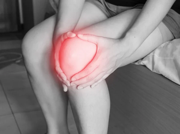 Mulheres tem inflamação e inchaço causar uma dor no joelho dolorido, lesões físicas desportivas quando o exercício . — Fotografia de Stock
