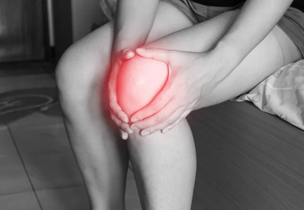 Las mujeres tiene inflamación e hinchazón causan dolor en la rodilla, lesiones físicas deportivas al hacer ejercicio . —  Fotos de Stock