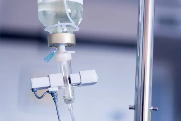 Detailní záběr odkapávací solný roztok pro pacienta a infuzní pumpy v nemocnici, léčbu nemoci doktor koncepce. — Stock fotografie