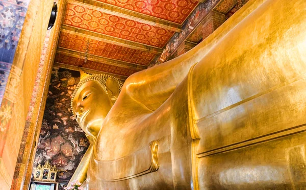Reclining Buddha gold statue face. Wat Pho in Bangkok, Thailand.