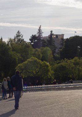 Atina, Yunanistan. 9 Mayıs 2019: Bir adam güneşli bir bahar gününde Akropolis 'in arka planında Yunan başkentinin caddesinde yürüyor