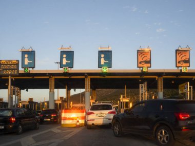 Central Greece. December 2019: Trip on the toll highway Athens-Thessaloniki, past cars, gas stations, toll checkpoints at sunset in the summer evening