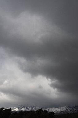 Yunanistan 'ın Evia (Euboea) adasındaki kara fırtına bulutlarının arka planında yer alan Dirfys Dağı' nın panoramik manzaralı zirveleri