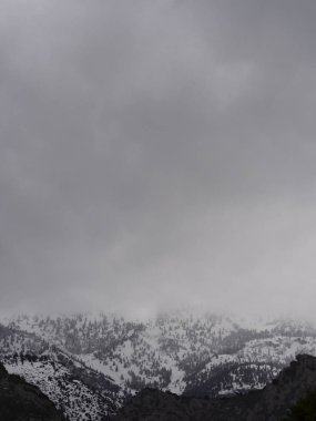 Yunanistan 'ın Evia (Euboea) adasındaki kara fırtına bulutlarının arka planında yer alan Dirfys Dağı' nın panoramik manzaralı zirveleri