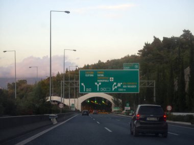 Periferiaki Imitou, Papagos Cholargos, Atina, Yunanistan. 20 Aralık 2019: Bir kış akşamı gün batımında Yunanistan 'ın başkentindeki bir tünelden arabalar geçiyor