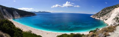 Yunanistan 'ın Kefalonya adasındaki İyon Denizi' nde güneşli bir günde berrak turkuaz suyla panoramik manzara Güzel Myrtos plajı