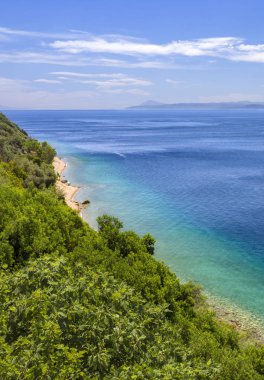 Ege Denizi 'ndeki Evia (Euboea) adasında Loutra-Edipsou' nun sıcak pınarları bulunan Yunan spa merkezindeki güzel ev ve palmiye ağaçları