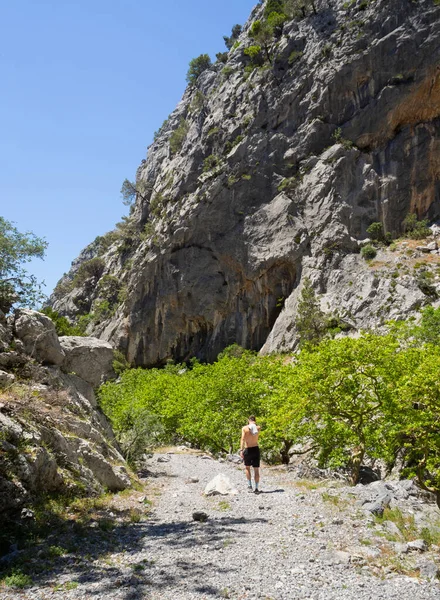 希腊爱维亚岛上 一名身穿短裤 头戴棒球帽的年轻人在阳光灿烂的一天 穿过高山峡谷 — 图库照片